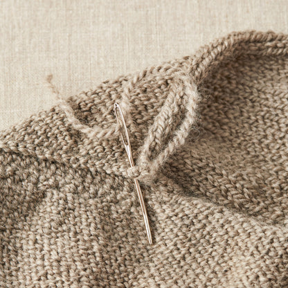 Cocoknits Tapestry Needle, Nadelset zum Vernähen von Strickstücken, hier in Aktion, steckt in einer Naht mit eingefädeltem Faden